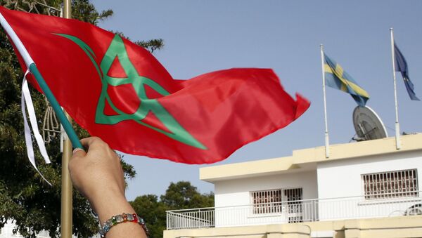 Moroccan woman waves her national flag outside the Swedish Embassy in Rabat, Morocco, as hundreds of protesters stage a protest against Sweden’s diplomatic position on Moroccan-controlled Western Sahara, Sunday, Oct. 4, 2015 - Sputnik Brasil