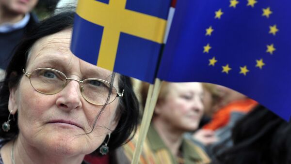 A woman holds a European flag and a Swedish flag as members of the Hungarian Jewish community and sympathizers walked on Szabadsag (Freedom) Bridge across the Danube River in downtown Budapest on April 15, 2012 during an Holocaust memorial ceremony - Sputnik Brasil