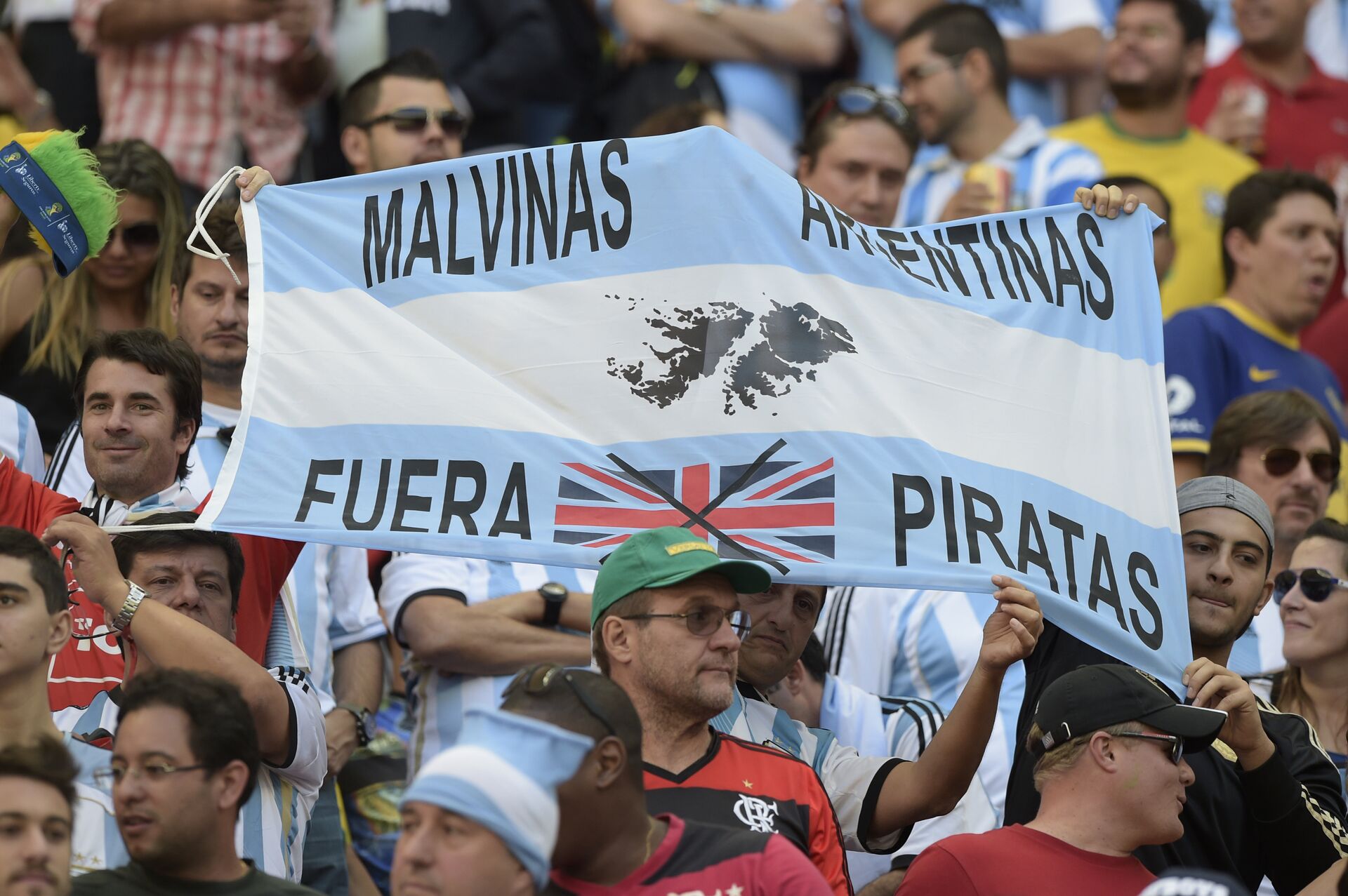 Torcedores seguram uma faixa com os dizeres Malvinas Argentina - fora piratas, durante as quartas de final da Copa do Mundo de 2014 entre Argentina e Bélgica - Sputnik Brasil, 1920, 02.03.2023