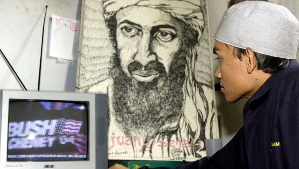 Um jovem muçulmano indonésio assiste a uma cobertura televisiva das eleições nos EUA na frente do retrato de Osama bin Laden, 03 de novembro de 2004 - Sputnik Brasil
