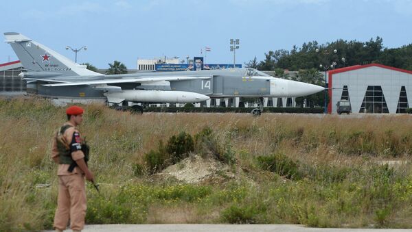 Um militar russo e o avião Su-24 na pista da base aérea de Hmeymim, Síria - Sputnik Brasil