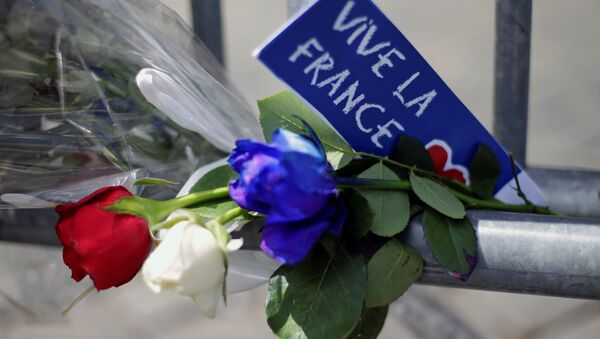 Flowers are seen attached to a fence to remember the victims of the Bastille Day truck attack in Nice in front of the French embassy in Rome. - Sputnik Brasil