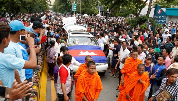 Um carro fúnebre carregando o corpo de Kem Ley, uma figura anti-governo e o cabeça de um grupo Khmer para Khmer, é cercado por seus partidários no caminho de um pagode para uma cerimônia budista depois que foi disparado morto em Phnom Penh. 10, julho, 2016. - Sputnik Brasil