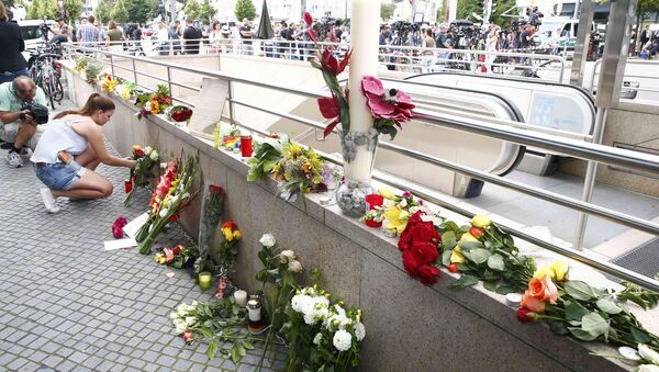 A women places flowers near the Olympia shopping mall, where yesterday's shooting rampage started, in Munich, Germany July 23, 2016. - Sputnik Brasil