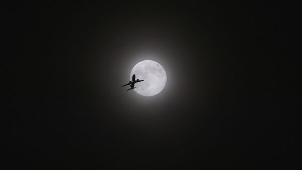 Um avião voa com a Lua em fundo sobre Kunming, no sudoeste da China, agosto de 2014 - Sputnik Brasil