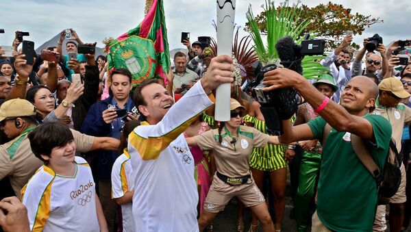 Prefeito Eduardo Paes ergue a tocha olímpica em frente à Escola Naval do Rio - Sputnik Brasil