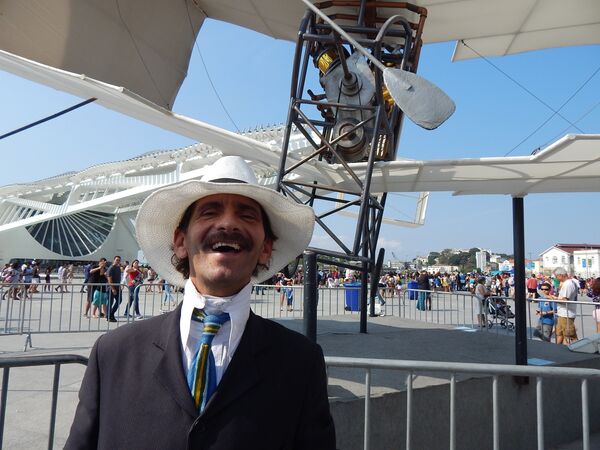 Homem fantasiado de Santos Dumont em frente à réplica do 14-Bis - Sputnik Brasil