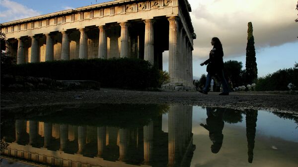 Um turista é refletido em uma poça de chuva enquanto ela passa pelo templo de Ifestos na antiga Ágora de Atenas, Grécia, 2.400 anos de idade. (foto de arquivo) - Sputnik Brasil