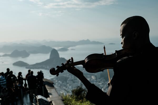 Um membro do conjunto Fino da Música toca violino na frente do Cristo Redentor, no Rio de Janeiro - Sputnik Brasil