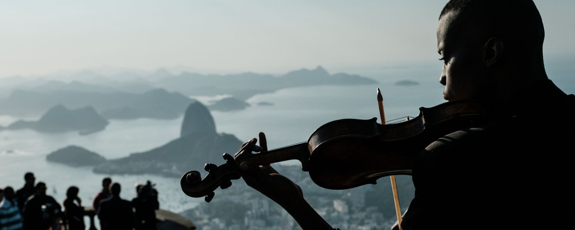 Um membro do conjunto Fino da Música toca violino na frente do Cristo Redentor, no Rio de Janeiro - Sputnik Brasil, 1920, 07.09.2023