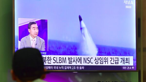 Homem vê notícias na TV sul-coreana sobre o lançamento de míssil balístico norte-coreano (foto de arquivo) - Sputnik Brasil