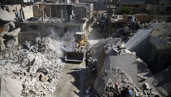 A front loader remove debris from a site hit by an airstrike in the rebel held Douma neighborhood of Damascus (File) - Sputnik Brasil