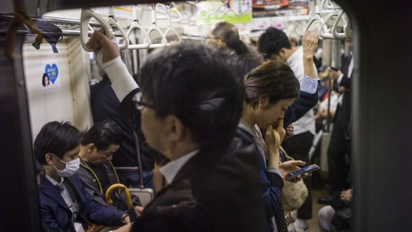 Uma mulher vendo seu celular no metrô em Tóquio, 12 de maio de 2015 - Sputnik Brasil