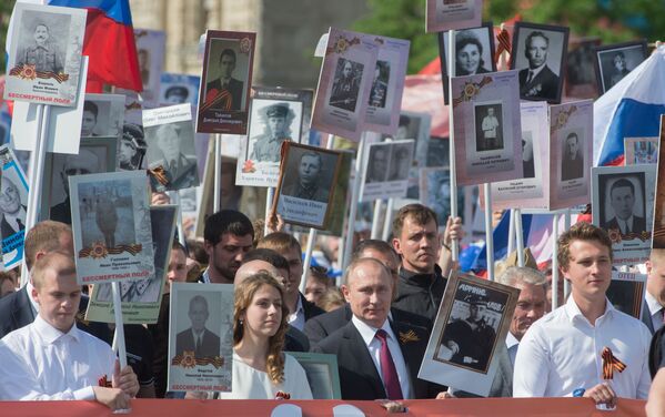 Presidente russo Vladimir Putin com retrato de seu pai, que combateu na Grande Guerra Patriótica, durante a ação patriótica Regimento Imortal na Praça Vermelha, Moscou, Rússia, 9 de maio de 2016 - Sputnik Brasil