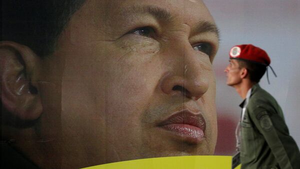 Soldado em frente do retrato do ex-presidente venezuelano Hugo Chávez - Sputnik Brasil