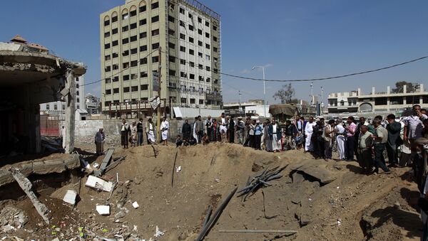 Yemenis gather around a crater caused by a Saudi-led airstrike that targeted a building in the centre of the capital Sanaa (File) - Sputnik Brasil