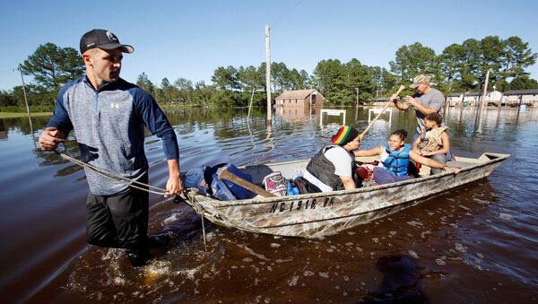 Socorristas evacuam família na Carolina do Norte, EUA, após a passagem do furacão Matthew - Sputnik Brasil