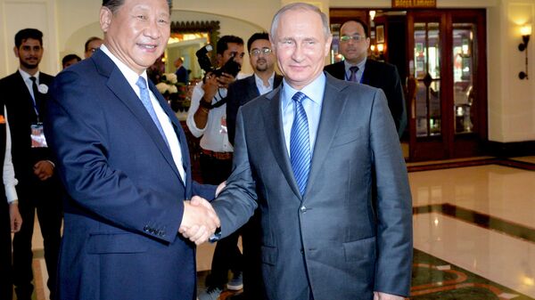 Presidente da China, Xi Jinping, e presidente da Rússia, Vladimir Putin, apertam as mãos às margens da Cúpula dos BRICS em Goa - Sputnik Brasil