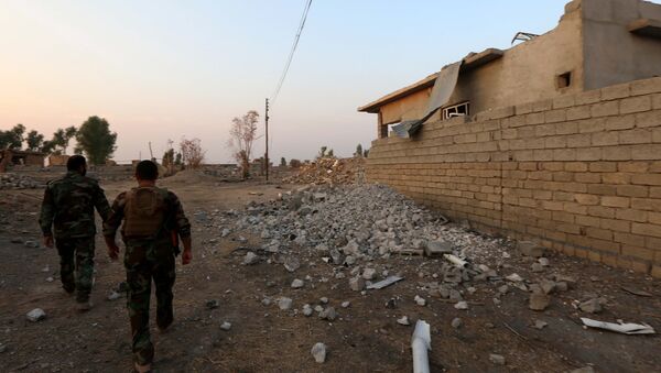 Combatentes de peshmerga passam um edifício destruido no leste de Mossul, Iraque, 26 de outubro de 2016 - Sputnik Brasil