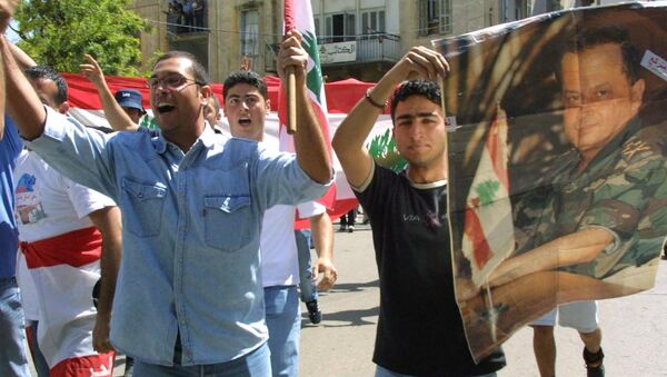 Estudantes libaneses mostram um cartaz com a foto de Michel Aoun junto com a bandeira nacional (foto de arquivo) - Sputnik Brasil