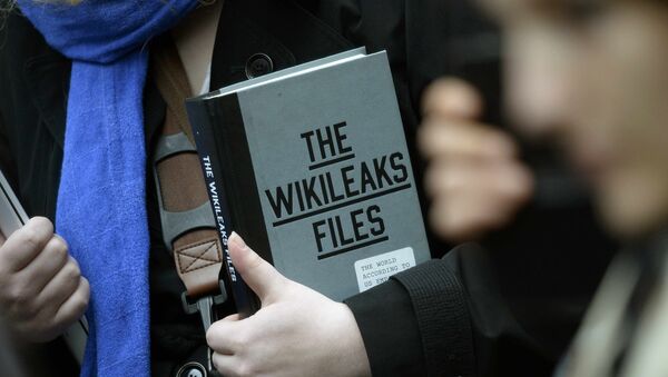 Simpatizante do fundador do WikiLeaks Julian Assange segurando uma cópia do The WikiLeaks Files - Sputnik Brasil