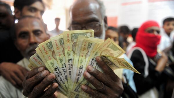 Um homem indiano segura nas mãos várias notas de 500 rupias, que perderam seu valor nominal após uma reforma do governo de Narendra Modi - Sputnik Brasil