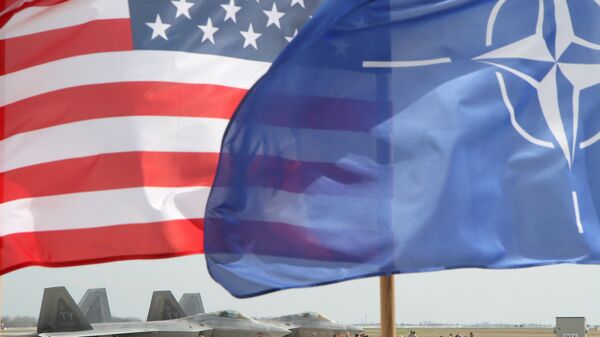 Bandeiras dos EUA e da OTAN em frente a caças F-22 Raptor da Força Aérea norte-americana, na Lituânia (imagem de arquivo) - Sputnik Brasil