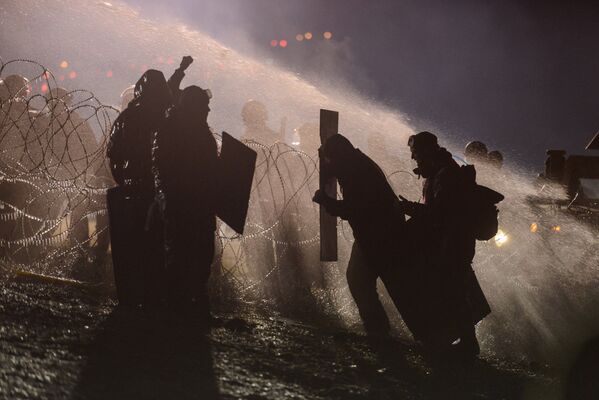 A polícia usa canhões de água para dispersar os protestantes contra a construção de um oleoduto em terras da reserva indígena de Standing Rock, em Dakota do Norte, em 20 de novembro de 2016 - Sputnik Brasil