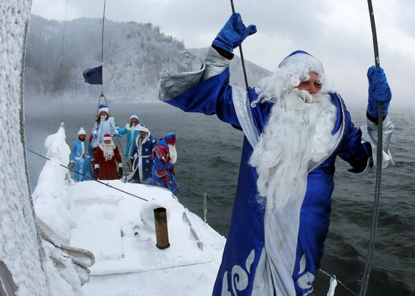Membros do clube náutico Skipper, disfarçados do personagem da tradição russa Ded Moroz (Avô do Frio, ou Papai Noel), ao lado da neta do Papai Noel russo Snegurochka navegam ao longo do rio Enisei, marcando o fim da temporada de veleiros a 21 graus centígrados negativos, em 21 de novembro de 2016 - Sputnik Brasil