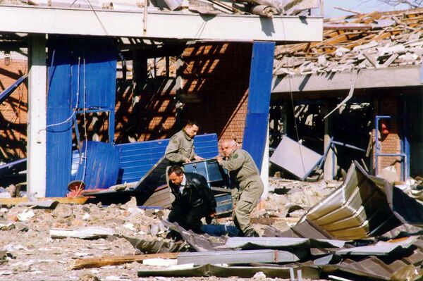 Trabalhadores limpam escombros de um centro de treinamento policial em Novi Sad, no norte da Iugoslávia, que foi destruída durante ataques aéreos da OTAN em 25 de março de 1999 (imagem de arquivo) - Sputnik Brasil
