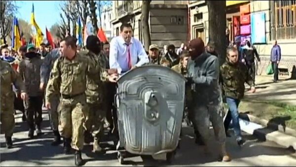 Radicais ucranianos empurrando o chefe do departamento de justiça de Ivano-Frankivsk em uma caçamba de lixo - Sputnik Brasil