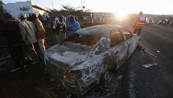 As pessoas olham para os destroços de um carro queimado, perto da cidade de Naivasha, Quênia. Dezembro, 11, 2016. - Sputnik Brasil