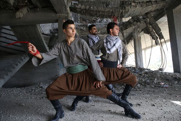 Dançadores palestinos executam dança tradicional Dabke em prédio destruído pela guerra entre Israel e Hamas - Sputnik Brasil