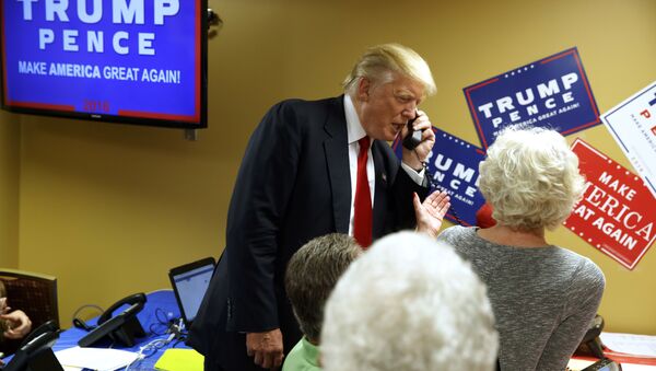 Presidente eleito dos EUA, Donald Trump, ao telefone, em visita a uma empresa de call center de Asheville, Carolina do Norte, durante campanha - Sputnik Brasil