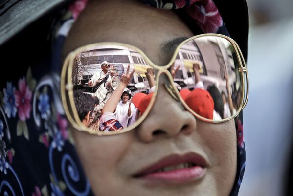 Manifestantes em Jacarta refletidos nas lentes de óculos de uma mulher - Sputnik Brasil