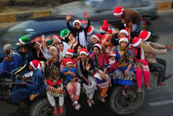 Pessoas vestidas de Papai Noel vão à cidade de Karachi no Paquistão para festejar o Natal - Sputnik Brasil