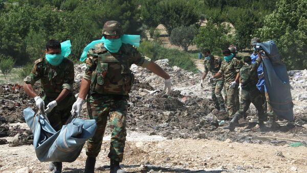 Forças sírias retiram corpos no local de enterramento em massa (foto de arquivo) - Sputnik Brasil