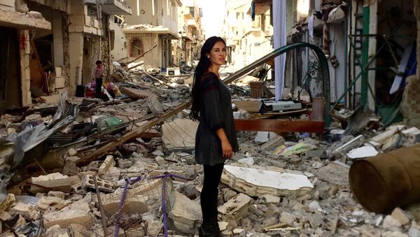 Cineasta boliviana Carla Ortiz em frente às ruinas da cidade síria de Aleppo - Sputnik Brasil