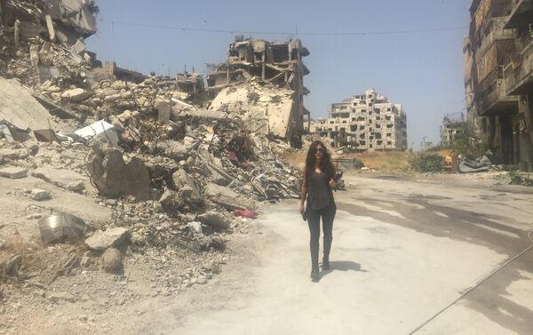 Carla Ortiz caminha entre prédios destruídos da cidade - Sputnik Brasil