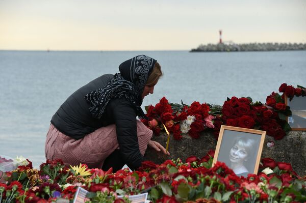 Mulher põe flores em memorial das vítimas do acidente aéreo com avião Tu-154 - Sputnik Brasil