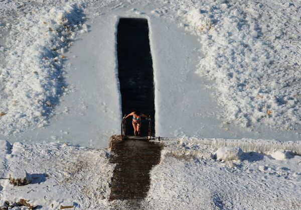 Mulher sai após mergulho em abertura no gelo na baía de Amur - Sputnik Brasil