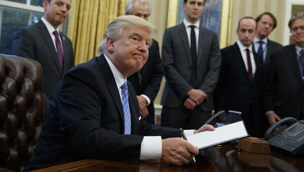 President Donald Trump looks up after signing the final of three executive orders, Monday, Jan. 23, 2017, in the Oval Office of the White House in Washington. (AP Photo/Evan Vucci) - Sputnik Brasil