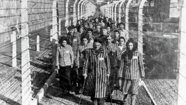 Vítimas do Holocausto marcham por uma das estreitas veredas do campo de concentração de Auschwitz (foto de arquivo) - Sputnik Brasil