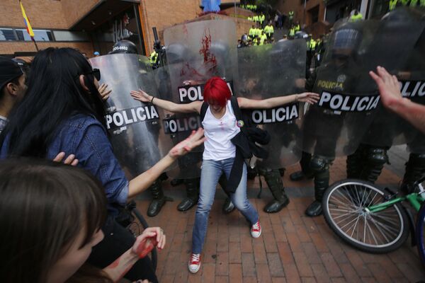 Moça tenta conter os policiais durante os protestos nas ruas de Bogotá, na Colômbia. - Sputnik Brasil