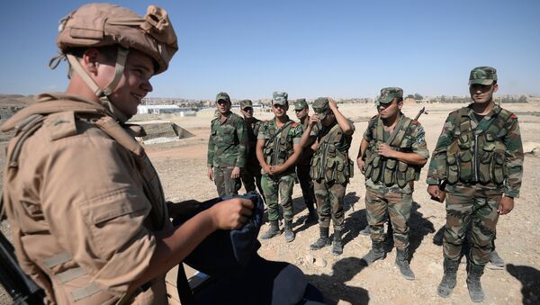 A Russian serviceman, left, trains Syrian soldiers to search and detect explosive devices in Palmyra. File photo - Sputnik Brasil
