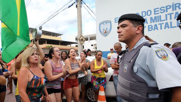 Um agente guarda a entrada da sede da PM em Cachoeira do Itapemirim, ES, enquanto moradores protestam contra a greve policial, que levou ao caos no estado, em 7 de fevereiro de 2017 - Sputnik Brasil