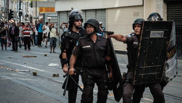 Policial aponta arma de fogo para manifestantes em protesto no Rio de Janeiro, 9 de fevereiro de 2017 - Sputnik Brasil