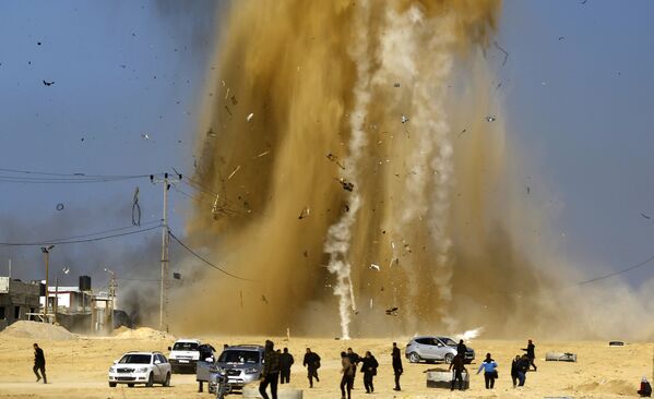 Palestinos correm para um refúgio em meio da fumaça após um ataque aéreo israelense contra um centro da organização palestina Hamas. - Sputnik Brasil