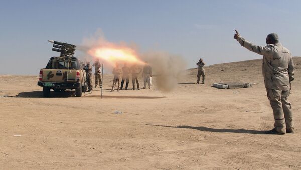 Forças de segurança iraquianas e Forças de Mobilização Popular suas aliadas disparam foguetes contra posições do Daesh em um campo petrolífero fora de Beiji, a cerca de 250 quilômetros ao norte de Bagdá, no Iraque, no sábado, 24 de outubro de 2015 - Sputnik Brasil