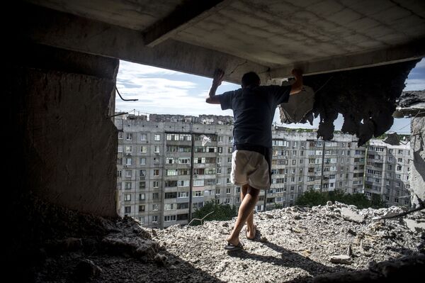 Foto da série Dias Negros da Ucrânia de Valery Melnikov, na qual aparece um homem que avalia a destruição de um prédio atingido por ataque de artilharia em Lugansk - Sputnik Brasil